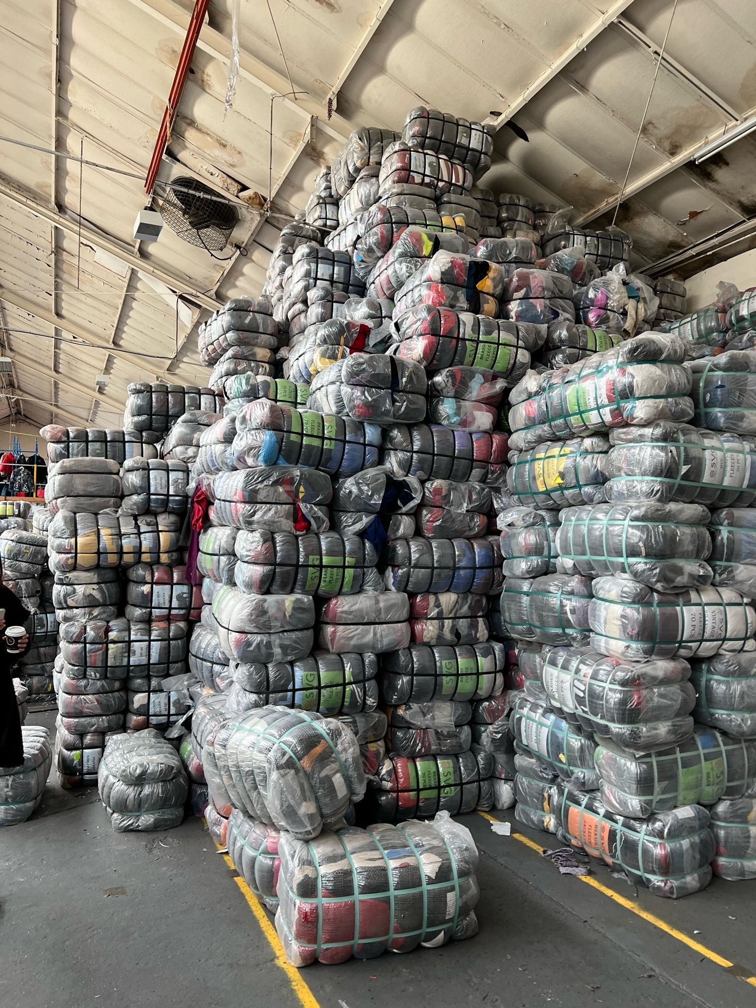 Bales of secondhand clothing in a sorting warehouse