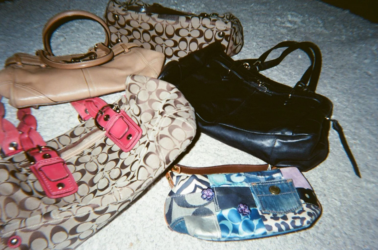 Coach handbags and shoes laid out on a carpet
