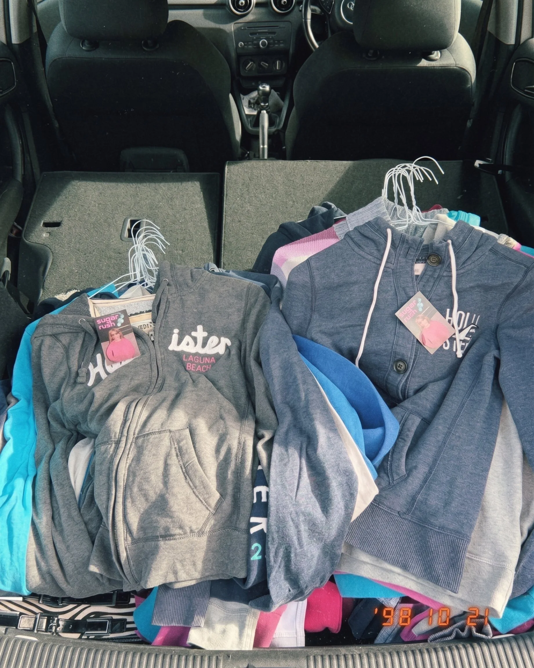 Hollister hoodies with tags stacked in a car boot