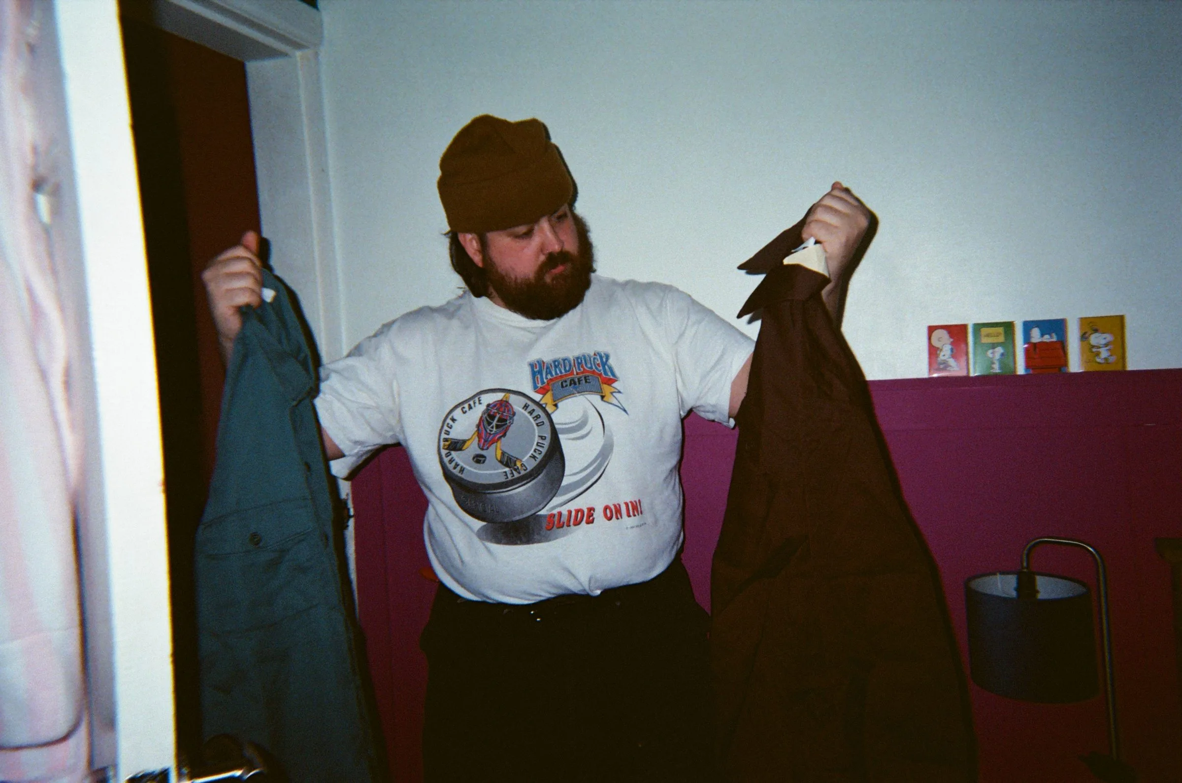 A reseller holding up two jackets at home