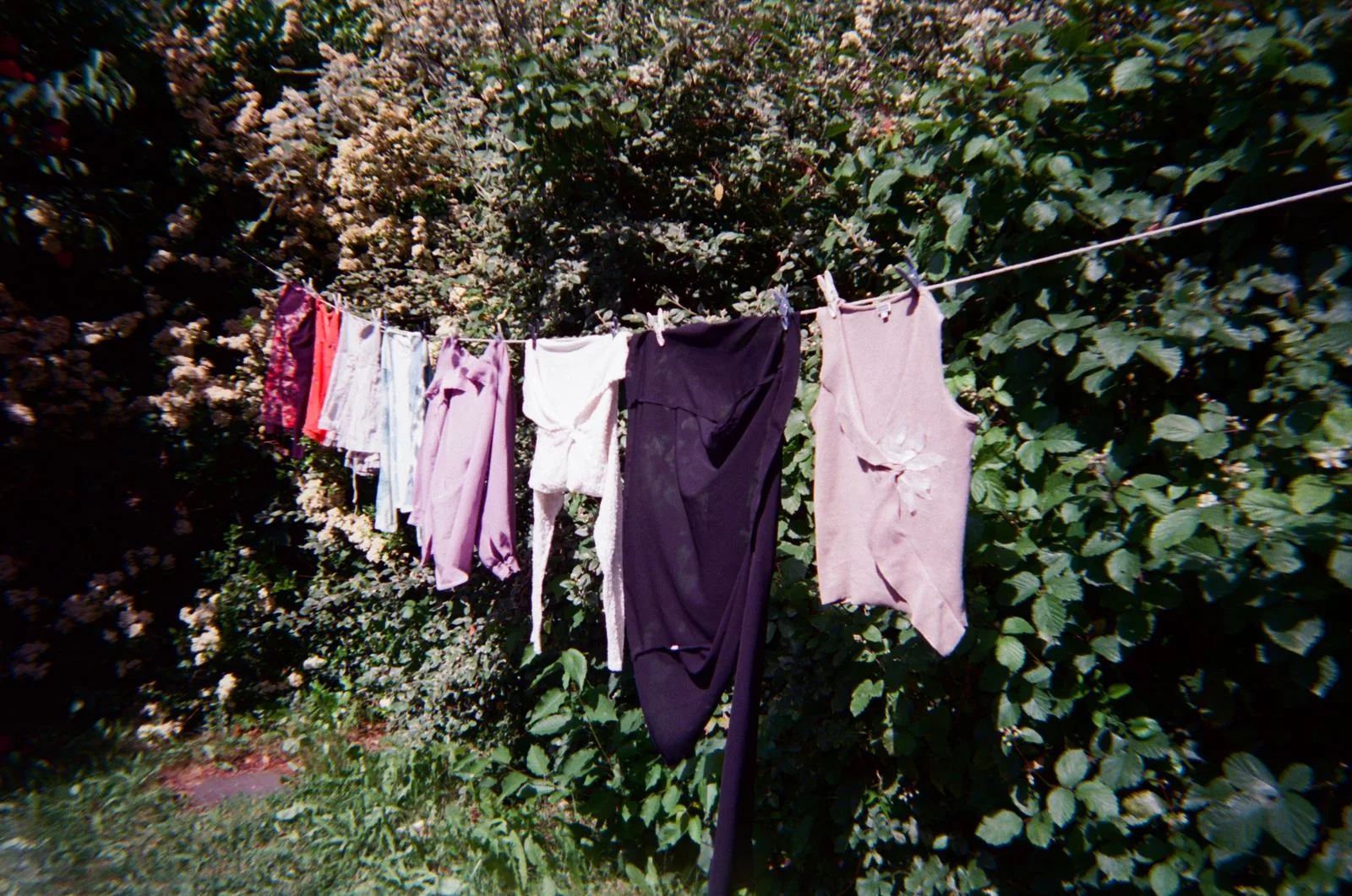 Secondhand clothes drying on a washing line in a garden